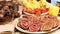 A counter with trays containing grilled sausages and meat. Round barbecue sausage street food showcase. Freshly grilled