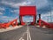 The counterweight and hydraulic rams of a red bascule bridge carrying road and pedestrian traffic across part of the docks complex