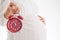 Counting hours expecting child birth. Motherhood concept. Pregnant woman holding alarm clock