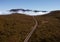 Country asphalt road ER209 leading to clouds stuck at mountain hills in the inland of Madeira island, Portugal aerial drone shot.