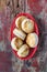 Country biscuits in red basket on rustic painted table in top down view