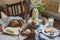 Country breakfast on rustic home kitchen with farm eggs, butter, wholegrain bread and milk.