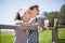 Country couple of farmers drink milk in field near fenc