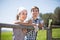 Country couple of farmers drink milk in field near fenc