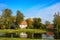 Country estate near the lake and forest, sunny autumn day. Leaf fall landscape