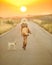 Country girl walking down a sunset road