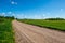 country gravel road with old and broken asphalt