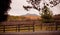 Country hill with wooden fence and bales of hay