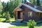 Country house with Windows made of laminated veneer lumber. Warm summer weather. Flowers in a pot.