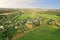Country houses in the countryside. Aerial view of roofs of green field with rural homes. Village with wooden home. Suburban house