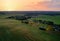 Country houses in the countryside. Aerial view of roofs of green field with rural homes. Village with wooden home. Suburban house