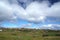 Country landscape with farmhouses under cloudy sky in Torshavn, Denmark. Beautiful landscape view. Hilly terrain with