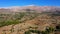 Country landscape with mountain valley on blue sky background.