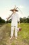 Country man in straw hat mowing grass in sunny day