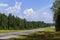 Country motorway in northern pine forest in Russia on sunny summer day