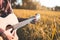Country music, Man playing acoustic guitar in rice field