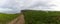 Country roaad leading to ocean and steep cliffs in green coastal landscape with cows