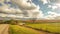 Country Road with Farmland and Cloudy Skies