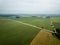 country road in green forest and fields drone aerial image