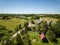 country road in green forest and fields drone aerial image