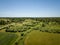 country road in green forest and fields drone aerial image