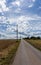 Country road leading to the horizon with a telephone pylon under an expressive sky