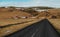 Country road with rural farm village in valley, Iceland