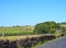 Country road with a stone wall surrounded by hills with green fields and farmhouses near luddenden in calderdale west yorkshire