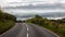 A country road in Wales in autumn with clouds in the valley.