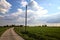 Country road with a wooden electricty pylons next to fields in the italian countryside in spring