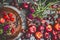 Country still life with various summer seasonal fruits and berries with garden flowers in plate on dark rustic background