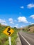 Country winding road sign with blue sky