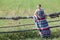 Countrygirl in light dress standing near village fence