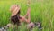 Countryside. A girl in a straw hat looks at the wildflowers.