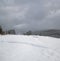 Countryside hills, groves and farmlands in winter remote alpine mountain village