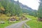 Countryside house, bench, mountain, green field, footpath in Switzerland