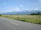 Countryside landscape with road, grassland and mountains