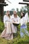 Countryside Lifestyle Concepts. Three Tranquil Caucasian Girls Together in Traditional Rural Dress With Basin of Linens Outdoors