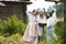 Countryside Lifestyle Concepts. Three Tranquil Caucasian Girls Together in Traditional Rural Dress With Basin of Linens Outdoors