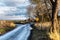 Countryside narrow road by the sea after a winter rain fall. Gloomy sky reflecting in a puddle conveys a sense of melancholy,