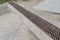 Countryside road drainage grate rusty metal steel grid grill mud