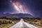 Countryside road with mountains and the milky way galaxy.
