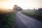 Countryside road among sunrise fields and meadows