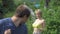 Countryside, woman neighbor in a swimsuit walks past a man in a garden