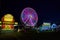 County fair ferris wheel with purple lights and carnival vendors