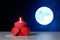 Couple of 3D red paper hearts, burning pink candle on white openwork paper napkin, full moon background closeup view selective