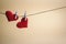 Couple of adorable red hearts hanging from a string by wooden pegs. Romantic Valentine`s Day scene with copy space.