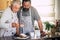 Couple of adult and senior man father and son or friends  bake together at home in the kitchen having fun - baking activity at