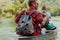 Couple adventurous explorer friends are canoeing in a wild river surrounded by the beautiful nature