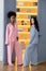 Couple of african and caucasian women in pajamas standing in doorway